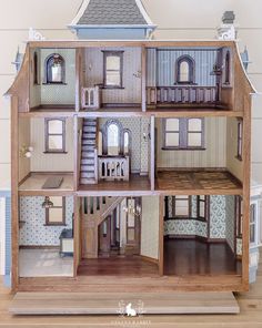 a wooden doll house with all the furniture and accessories in it's display case