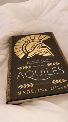 a book on the bed with an image of a spartan's helmet in gold