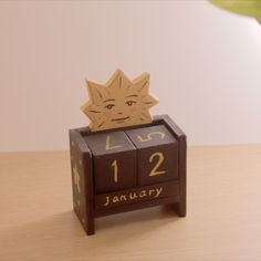 a wooden calendar sitting on top of a table