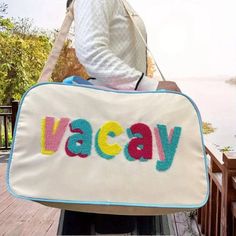 Description: Get ready for your next adventure with the VACAY Travel Bag. Features a vibrant and playful design with the word "VACAY" in colorful letters. Spacious interior, perfect for packing all your travel essentials. 9”W x 12”H x 20.5”L Material & Care: Fabric: Durable and lightweight polyester blend. Care Instructions: Wipe clean with a damp cloth. Do not bleach. Handle with care to maintain the vibrant colors. Large Capacity Multicolor Travel Bag, Playful Rectangular Travel Shoulder Bag, Colorful Large Capacity Travel Bag, Multicolor Large Capacity Luggage For Weekend Trips, Colorful Large Capacity Bags For Travel, Playful Rectangular Travel Luggage, Playful Rectangular Luggage For Travel, Large Capacity Multicolor Luggage For Weekend Trips, Playful Rectangular Shoulder Bag For Travel