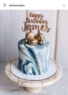 a birthday cake with blue marble and gold decorations