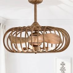 a wooden light fixture hanging from the ceiling in a room with white walls and curtains