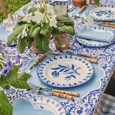 a blue and white table set with place settings