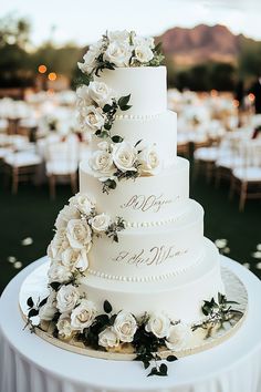 a wedding cake with white flowers and greenery