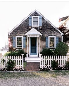 a small house with a picket fence around it