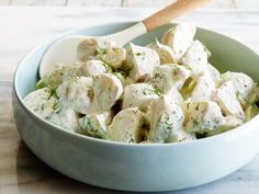 a white bowl filled with chicken salad on top of a table