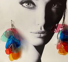 a pair of multicolored plastic earrings hanging from the side of a woman's face