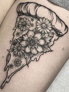 a woman's thigh with flowers on it and a piece of pizza in the middle