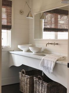 a bathroom with two sinks and baskets on the counter