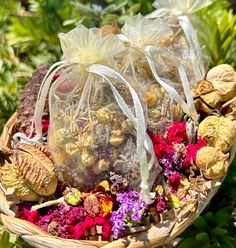 three bags filled with different types of flowers and nuts in the middle of a basket