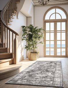 a living room with an area rug, potted plant and stairs leading to the beach