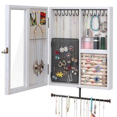 an open jewelry cabinet with necklaces and earrings