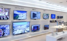 there are many televisions on display in the store, all displaying different types of screens