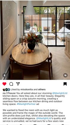 an image of a table with flowers on it in the middle of a room that has sliding glass doors