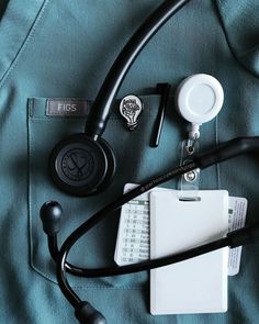 an assortment of medical supplies laid out on top of a blue sheet with black stethoscopes