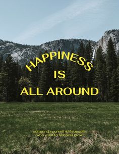 the words happiness is all around are in front of a mountain with trees and grass