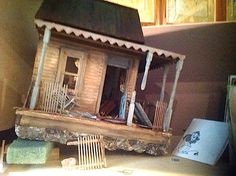 a doll house sitting on top of a table next to a chair and other items