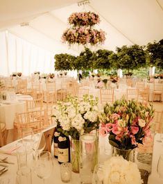 the tables are set with flowers and wine bottles