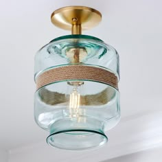 a glass light fixture with a rope around it