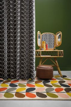 a chair sitting on top of a rug in front of a window covered with curtains