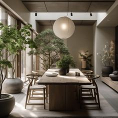 a dining room table surrounded by potted plants and large vases with trees in them