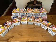 a table topped with lots of small boxes filled with candy and candies next to a christmas tree