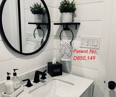 a bathroom sink with two plants on the shelf above it and a toilet paper dispenser next to it