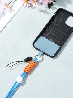 an orange and blue toothbrush holder attached to a cell phone case on a table