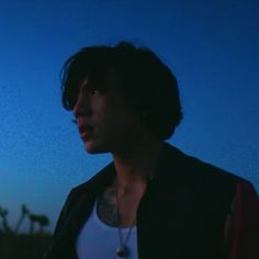 a man standing in front of a blue sky with palm trees on the other side