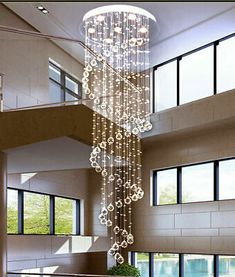 a large chandelier hanging from the ceiling in a room with windows and stairs