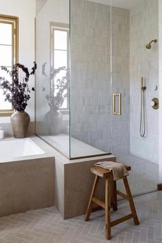 a bathroom with a tub, shower and stool