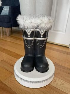 a pair of black boots sitting on top of a wooden floor