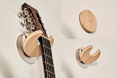 an acoustic guitar is hanging on the wall next to two other pieces of wood that are shaped like moon and crescents