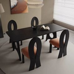 a black table with chairs and a book on it in front of a large window