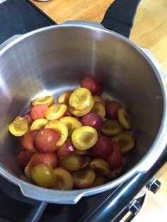 grapes are being cooked in a large pot on the stove top, ready to cook