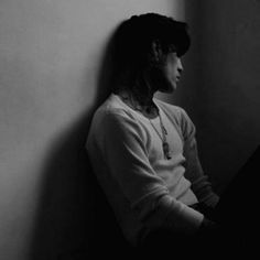 black and white photograph of a woman leaning against a wall