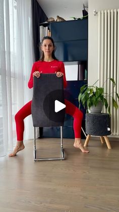 a woman in red is sitting on a chair