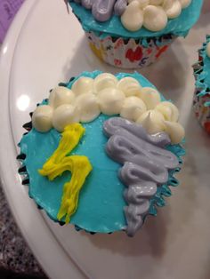 three cupcakes decorated with icing on a plate