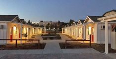 a row of small white houses sitting next to each other on a street at night