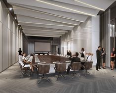 a group of people sitting around a conference table in an office setting with white walls and wood flooring