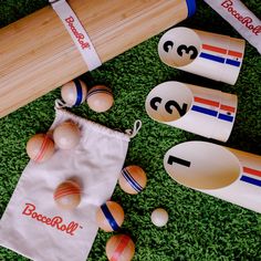 several different types of wooden baseball bats and balls in a bag on the ground with grass