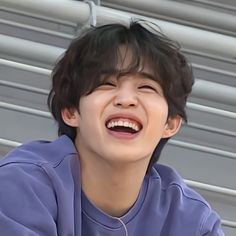 a young boy laughing while sitting down