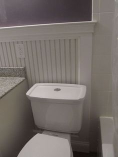 a white toilet sitting in a bathroom next to a sink