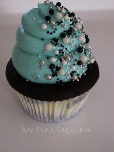 a cupcake with blue frosting and pearls on top