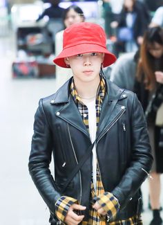 a young man wearing a red hat and black leather jacket