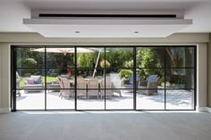 an empty room with sliding glass doors leading to the outside patio and dining table area