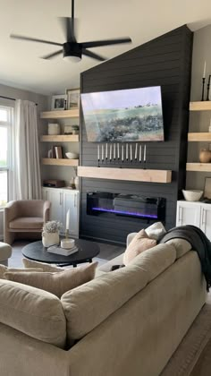 a living room filled with furniture and a flat screen tv mounted on the wall above a fireplace