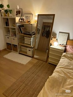 a bedroom with a bed, dresser and bookshelf next to a mirror on the wall