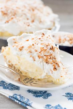 a slice of coconut cream pie on a white plate with a blue and white napkin