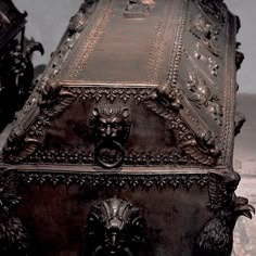 an ornately carved metal box with two lions on it's sides and the lid open